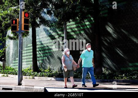 Couple d'âge moyen marchant dans la rue en début de soirée, Barcelone, Espagne. Banque D'Images