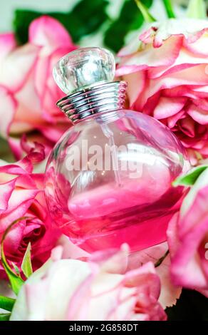 une bouteille de parfum parmi de belles fleurs Banque D'Images