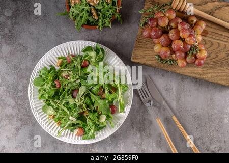 Salade délicieuse à base de raisins grillés caramélisés, d'arugula poivrée, de noix grillées et de pecorino. Excellent repas végétarien. Banque D'Images