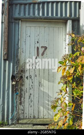 Matériaux de construction mixtes et numéro 17 sur la porte en bois d'un ancien hangar à bateaux Banque D'Images