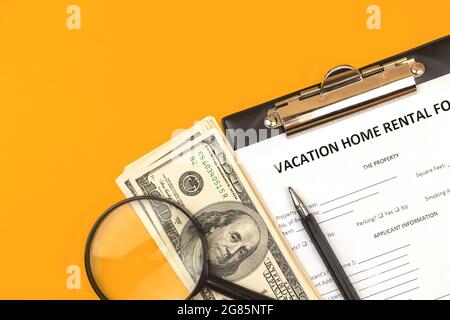 Formulaire de location de maison de vacances. Concept de crédit hypothécaire, presse-papiers avec accord, argent et stylo. Vue de dessus Banque D'Images