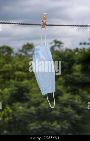 Suspendre un masque chirurgical avec une corde à linge pour sécher Banque D'Images