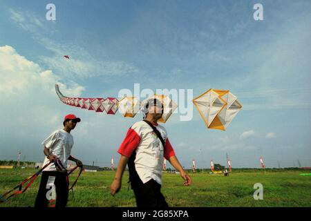 Des hommes volant un cerf-volant géant lors du festival international du cerf-volant de Jakarta 2004 qui s'est tenu le 9-11 juillet à Carnival Beach à Ancol Dreamland, dans le nord de Jakarta, en Indonésie. Banque D'Images