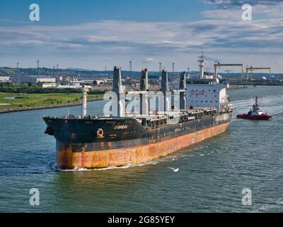 Le transporteur de vrac Cabrera quitte le port de Belfast en juin 2021 lors d'une soirée claire et ensoleillée en juin 2021. Le navire est escorté par le bateau à remorqueurs Masterman. Banque D'Images