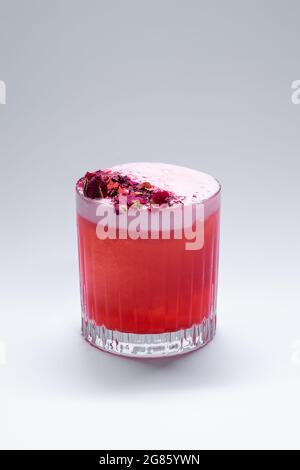 cocktail au club de trèfle avec pétales de framboise et de rose sur fond blanc Banque D'Images