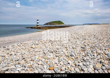 La plage de galets à Penmon point avec le phare et Puffin Island en arrière-plan, Anglesey, au nord du pays de Galles Banque D'Images