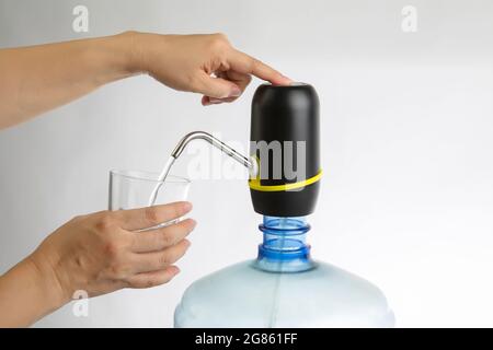 femme appuyez à la main sur le filtre de purification d'eau pour l'eau potable sur fond blanc Banque D'Images