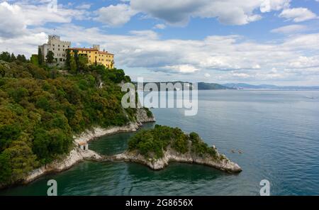 Château de Duino sur le promontoire rocheux de la côte Adriatique près de Trieste, Italie, avec la ville d'horizon loin dans le fond Banque D'Images