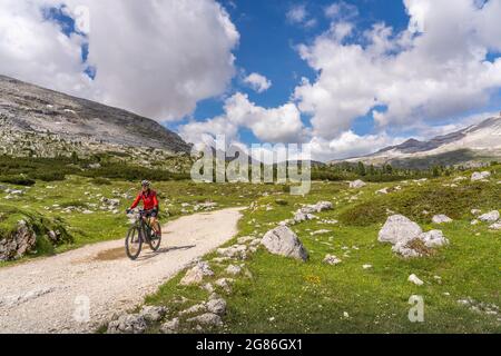 Jolie femme sénior très active à vélo électrique dans la haute vallée de Fanes, une partie du parc naturel de Fanes-Sennes-Baies, Dolomites, Italie Banque D'Images