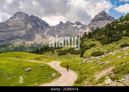 Jolie femme sénior très active à vélo électrique dans la haute vallée de Fanes, une partie du parc naturel de Fanes-Sennes-Baies, Dolomites, Italie Banque D'Images