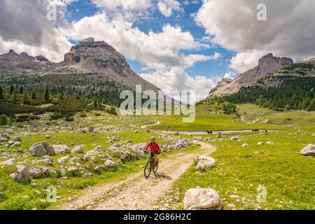 Jolie femme sénior très active à vélo électrique dans la haute vallée de Fanes, une partie du parc naturel de Fanes-Sennes-Baies, Dolomites, Italie Banque D'Images