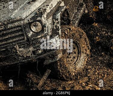 voyage en 4x4 trekking. Vue du bas sur une grande roue de voiture sur la route de campagne et la toile de fond des montagnes. suv Safari. Hors du véhicule sortant d'un trou de boue Banque D'Images