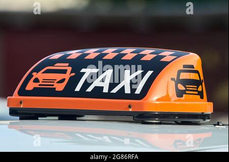 un panneau de taxi orange se trouve sur le toit de la voiture Banque D'Images