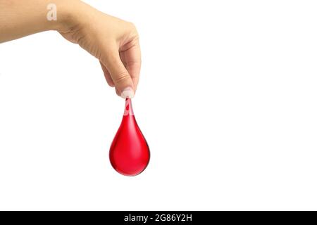Main tenant la goutte de sang sur fond blanc. Don de sang, transfusion sanguine, Journée mondiale du don de sang, Journée mondiale de l'hémophilie. Banque D'Images
