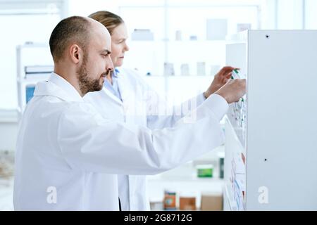 vue latérale. un homme et une femme pharmaciens discutent de médicaments. photo avec un espace de copie. Banque D'Images