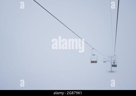 Les téléphériques pendent les câbles dans un brouillard silencieux Banque D'Images