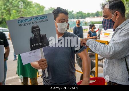 New Delhi, Inde. 17 juillet 2021. Un photojournaliste met un ruban noir sur le bras d'un collègue lors de la réunion en mémoire.Press Club India (PCI) et l'association de caméraman des nouvelles de travail (YWCA) ont organisé une réunion en mémoire aux chandelles pour le Siddiqui danois. Lauréat du prix Pulitzer, le photographe en chef de Reuters, Danish Siddiqui, a été tué dans le district de Spin Boldak, à Kandahar, en Afghanistan. Le journaliste indien couvrait la situation de guerre à Kandahar. Crédit : SOPA Images Limited/Alamy Live News Banque D'Images