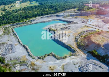 Extraction de pierre à ciel ouvert dans le canyon avec lac vert profond sur la vue aérienne Banque D'Images