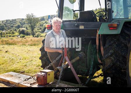 Kealkill, Bantry, Cork, Irlande. 17 juin 2021. L'agriculteur Seán O'Connor connecte une tondeuse à fléaux à son tracteur avant de commencer à se tailler sur son terrain à Kealkill, Co. Cork, en Irlande. - photo; David Creedon Banque D'Images