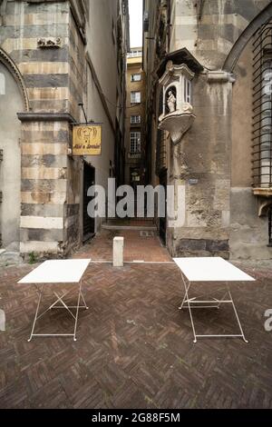 Gênes, Italie, centre historique ; deux tables en plein air d'un restaurant local sur la Piazza San Matteo Banque D'Images