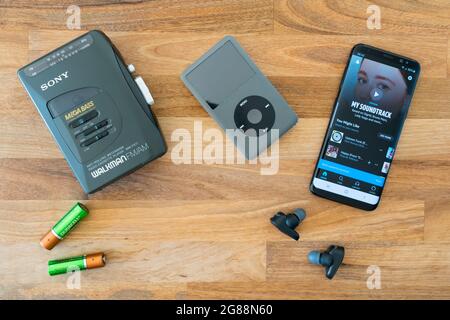 Technologie de musique portable en évolution : un Walkman ® Sony obsolète avec batteries, un iPod Apple obsolète et Amazon Music sur un smartphone Android Banque D'Images