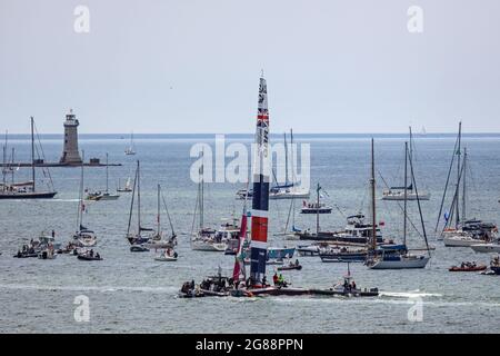 Team Great Britain à bord de leur catamaran pour les courses de SailGP à Plymouth Sound juillet 2021. Ils sont entourés de spectateurs dans de petits bateaux. Banque D'Images