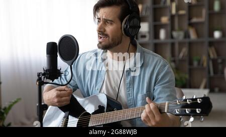 Joyeux jeune musicien masculin créant sa propre musique. Banque D'Images