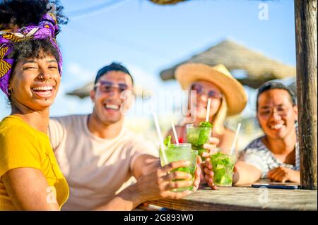 Amis multiraciaux boire des cocktails mojito dans un restaurant de plage en plein air en été - concept sur les gens heureux ayant le plaisir, l'amitié et Banque D'Images