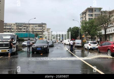 Pékin, Chine. 18 juillet 2021. Photo prise avec un téléphone portable le 18 juillet 2021 montre que les inondations sont évacuées des sous-sols voisins après que les pluies ont frappé le district de Haidian à Beijing, capitale de la Chine. L'Observatoire météorologique de Beijing a émis dimanche matin un avertissement orange pour les pluies accumulées dans certaines zones de la capitale ayant dépassé 150 mm. Credit: Xinhua/Alay Live News Banque D'Images