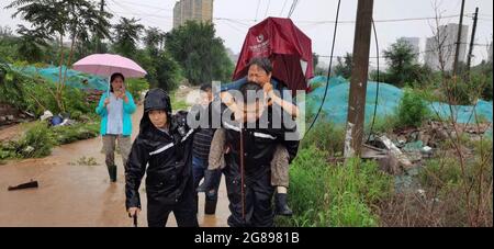 Pékin, Chine. 18 juillet 2021. Les policiers transfèrent des personnes bloquées après que les pluies aient frappé le district de Mentorgou à Beijing, capitale de la Chine, le 18 juillet 2021. L'Observatoire météorologique de Beijing a émis dimanche matin un avertissement orange pour les pluies accumulées dans certaines zones de la capitale ayant dépassé 150 mm. Credit: Xinhua/Alay Live News Banque D'Images