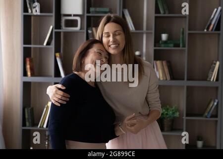 Bonne mère d'âge moyen et fille adulte qui s'embrasse à la maison Banque D'Images
