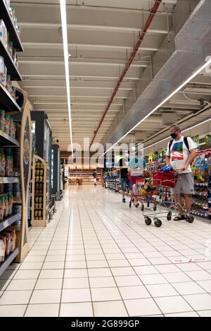 Varsovie, Pologne - 27 juin 2021 : personnes avec des paniers de shopping alignés pour les groats au magasin. Faire du shopping dans un supermarché pendant l'épidémie de COVID-19. Banque D'Images