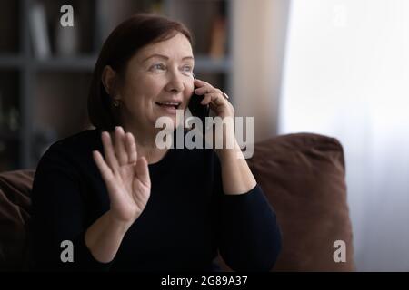 Bonne femme âgée des années 60 parlant sur téléphone portable Banque D'Images