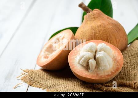 Moitié Santol sur fond de bois blanc, Santol a le goût aigre et le milieu de santol est plus doux. C'est un fruit très célèbre de la province de Lophuri. THAÏLANDE Banque D'Images
