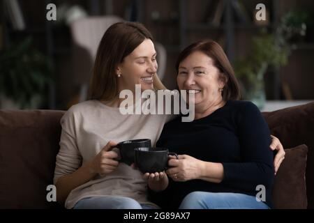 Bonne fille grognup et maman d'âge moyen plus âgée buvant du thé Banque D'Images