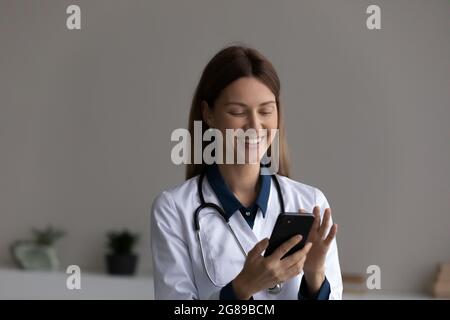 Bonne femme médecin utilisant l'application sur smartphone pour prendre rendez-vous Banque D'Images