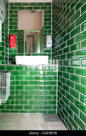 Jetez un coup d'œil dans une toilette extraordinaire. Avec lavabo. Les petites tuiles vert foncé sont particulièrement visibles Banque D'Images