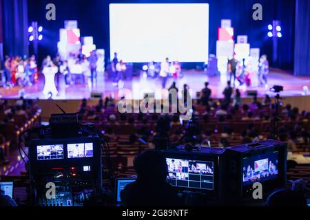 Image floue de l'équipe d'ingénieurs du son travaillant pour se préparer à la scène de concert. L'équipe en coulisses contrôle et surveille la production vidéo derrière le Banque D'Images