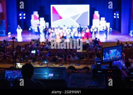 Image floue de l'équipe d'ingénieurs du son travaillant pour se préparer à la scène de concert. L'équipe en coulisses contrôle et surveille la production vidéo derrière le Banque D'Images