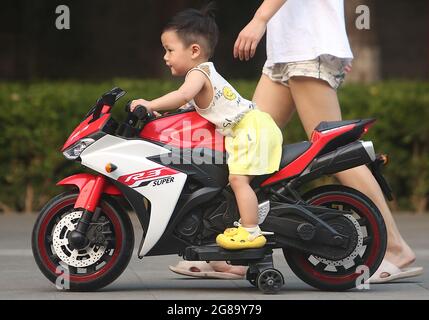 Pékin, Chine. 18 juillet 2021. Un garçon chinois joue dans un parc sur son vélo électrique miniature à Beijing, le dimanche 18 juillet 2021. Selon une nouvelle déclaration du gouvernement, les étudiants chinois ne seront pas autorisés à rentrer dans les écoles publiques à moins que toute leur famille ne soit entièrement vaccinée. Photo de Stephen Shaver/UPI crédit: UPI/Alay Live News Banque D'Images