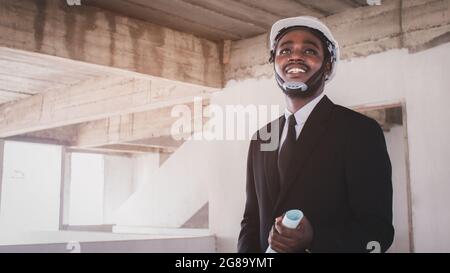 Le directeur des architectes africains travaillant avec une tablette travaille ensemble à l'intérieur du chantier de construction Banque D'Images