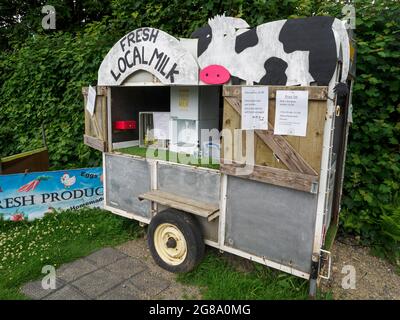 Les produits frais de GEM, les recharges de lait étant vendues à partir d'une vieille remorque sur le côté de la route, South Trewisey Farm, près de North Hill, Cornwall, Royaume-Uni Banque D'Images