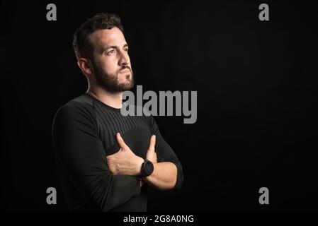 Portrait d'un homme adulte avec les bras croisés regardant sur le côté Banque D'Images