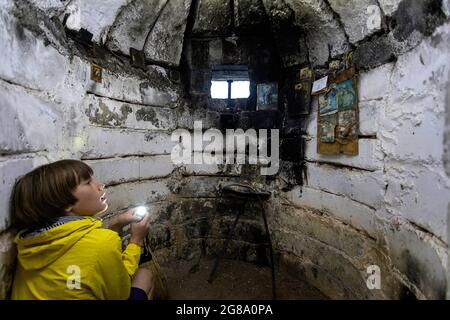 Garçon avec une torche à l'intérieur d'un bunker, Lin, Albanie Banque D'Images