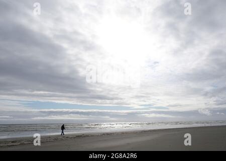 Moody image de randonneurs silhouetted sur la plage à côté de l'océan Pacifique, Pacific Beach, Washington State USA. Banque D'Images