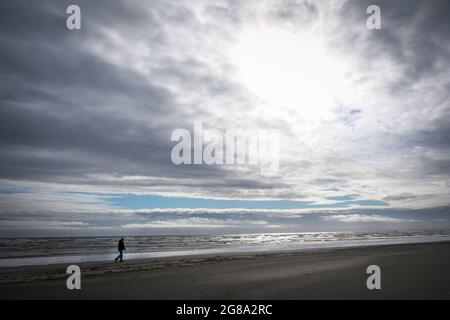 Moody image de randonneurs silhouetted sur la plage à côté de l'océan Pacifique, Pacific Beach, Washington State USA. Banque D'Images