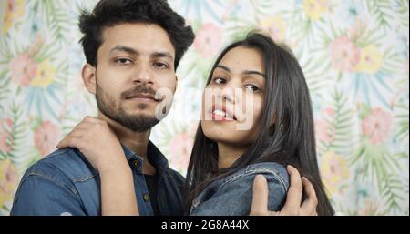Un jeune couple indien se posant tout en s'embrassant à la maison Banque D'Images