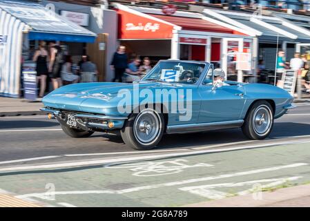 Chevrolet Corvette C2 Sting Ray voiture classique conduite le long de la route de bord de mer à Southend on Sea, Essex, lors d'une chaude journée d'été à côté des cafés Arches Banque D'Images