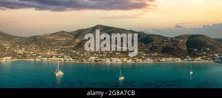 Île de Sifnos, Platis Gialos, Cyclades Grèce. Vue panoramique du village traditionnel coucher de soleil coloré sur le ciel bleu foncé plage de sable de mer. Bateaux amarrés su Banque D'Images