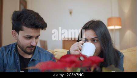 Un jeune couple indien boit du café et passe du temps à la maison Banque D'Images